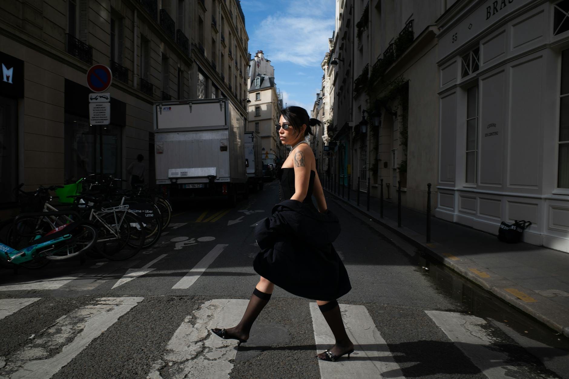 Elegancka kobieta przechodzi przez ulicę w centrum Paryża