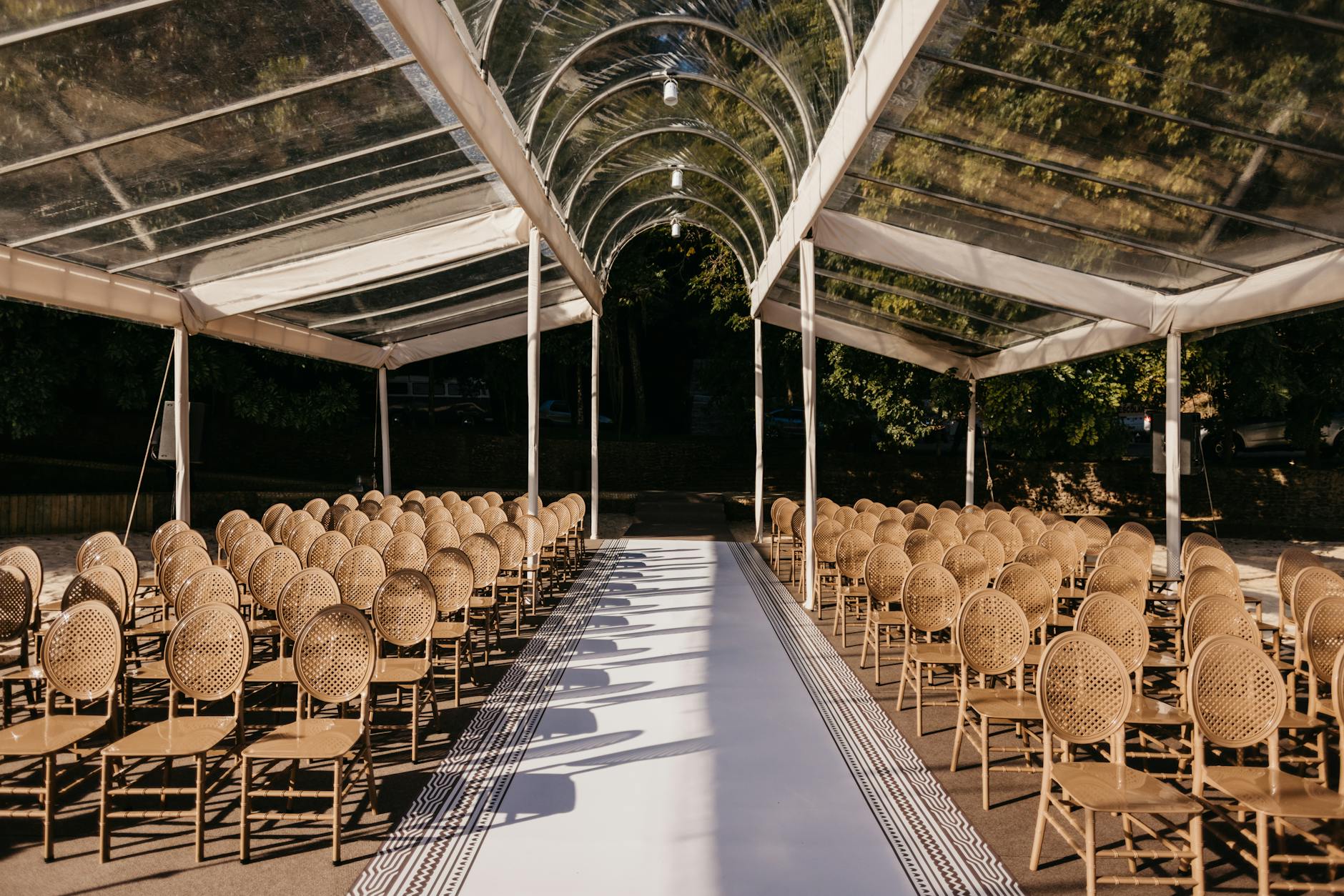 Plenerowa sala weselna z eleganckimi stołami pod przezroczystym dachem